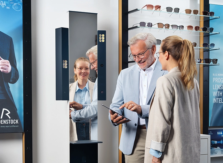 Un opticien conseille une cliente devant la borne de mesure ImpressionIST